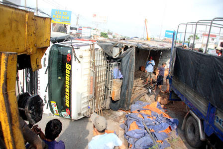 Đâm dải phải phân cách, xe tải chở gỗ lật nhào giữa quốc lộ